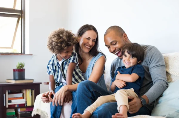 Family sitting on a couch smiling | Anderson Pest Solutions serving Illinois and Indiana