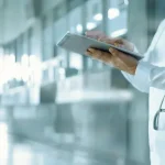 Doctor standing in hospital hallway with a tablet | Anderson Pest Solutions serving Illinois and Indiana