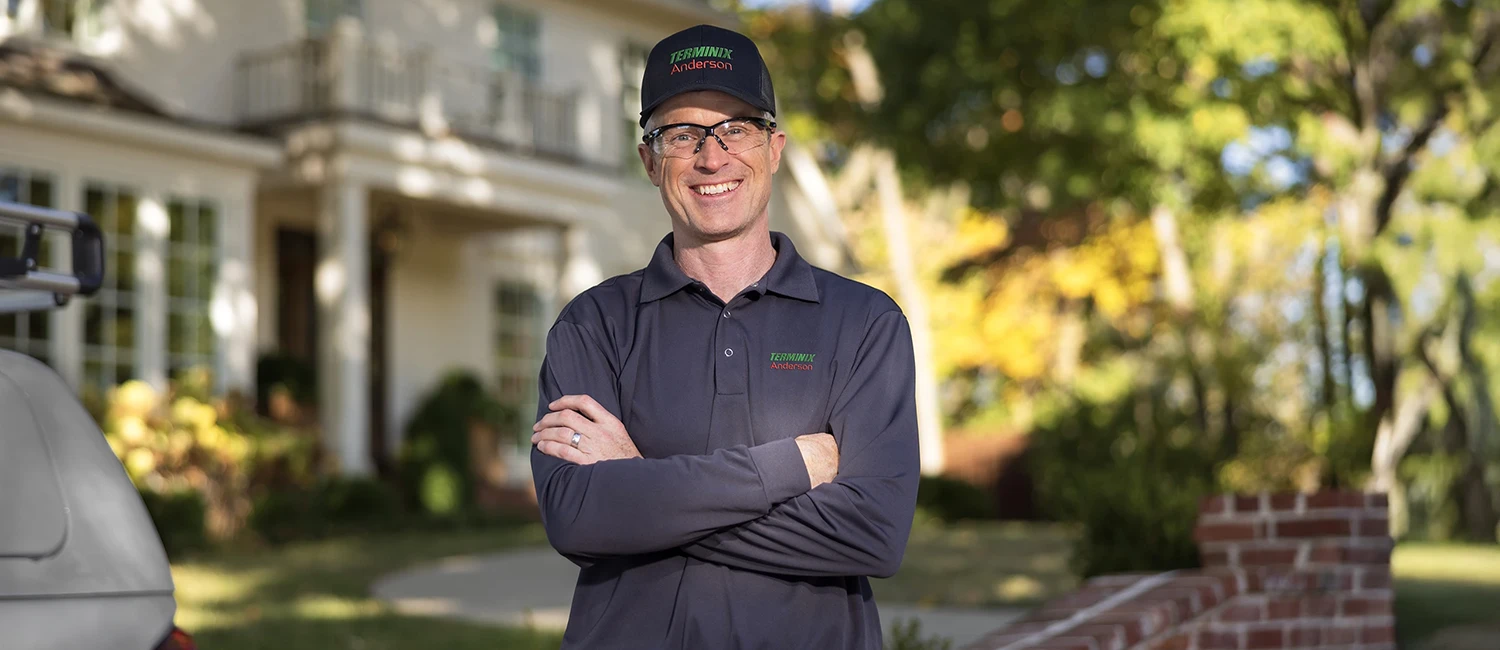 Pest control technician with a customer in front of a home - Keep pests away with Terminix Anderson