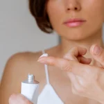 A woman with bed bug bite cream on the tip of her finger